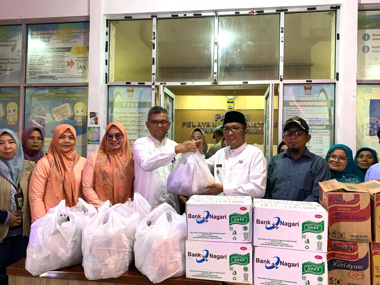 Pemimpin Bank Nagari Cabang Pasar Raya Hendri Masri menyerahkan bantuan untuk korban banjir kepada Wali Kota Padang Hendri Septa, di Kantor Camat Padang Selatan, Jumat (8/3)